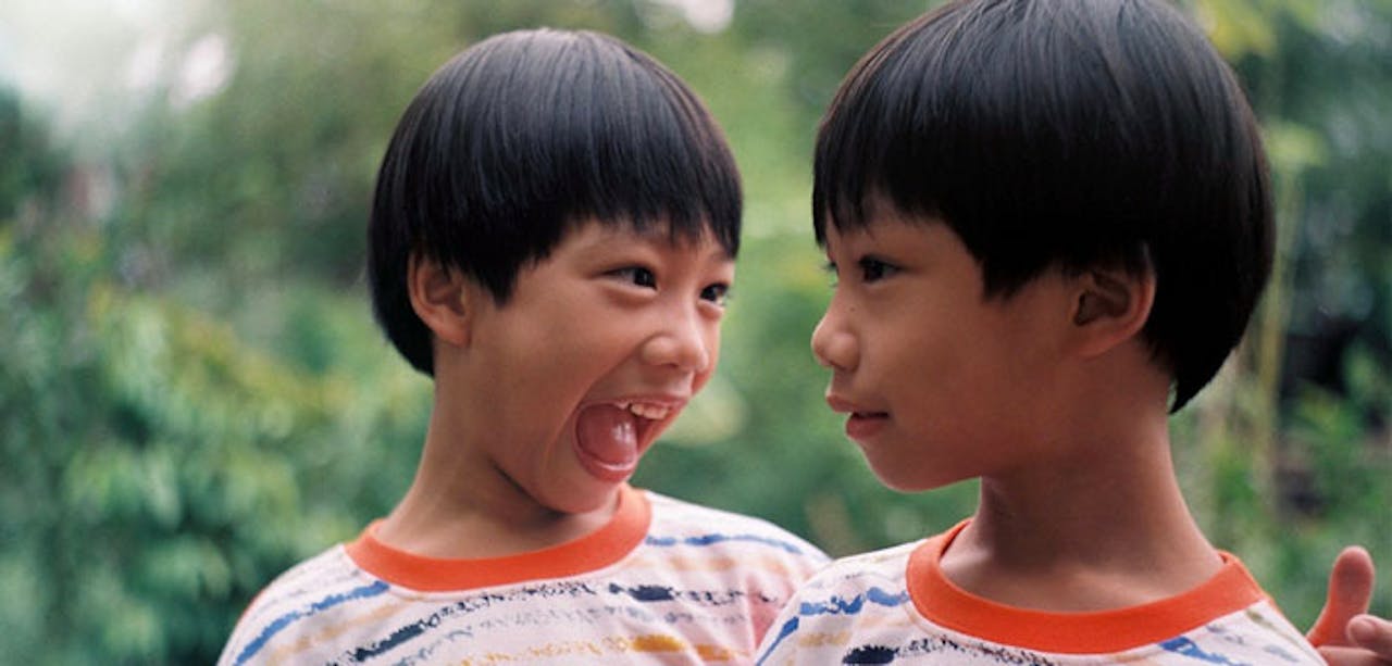 Twee Aziatische jongens lachen elkaar uit.