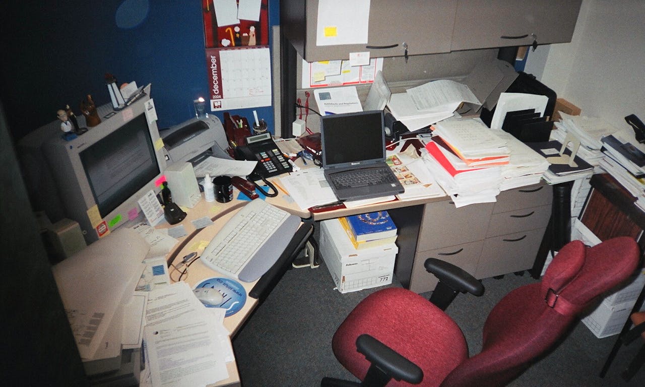 Een rommelig bureau in een kantoor.