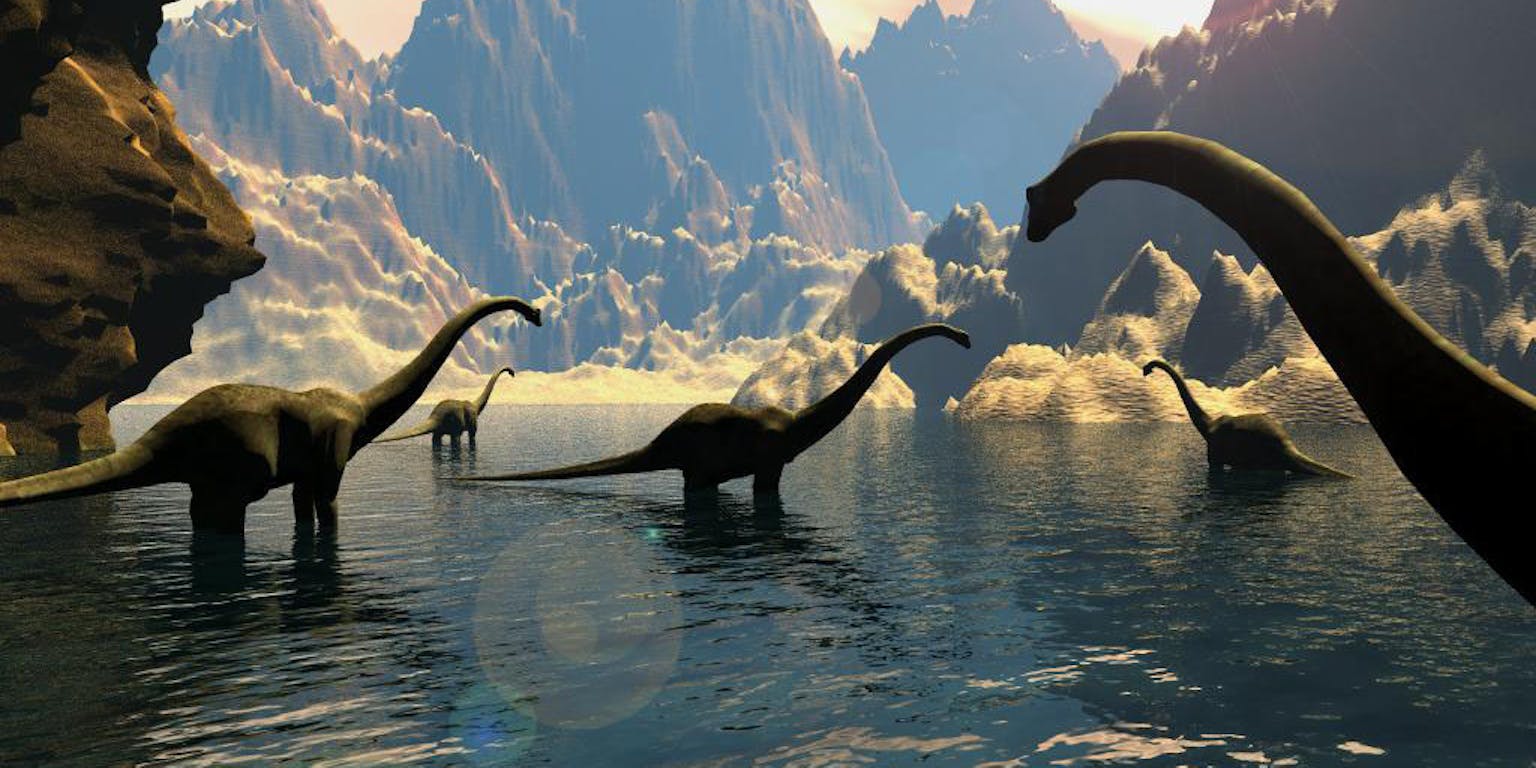 Een groep dinosaurussen in het water. Op de achtergrond zijn rotsformaties te zien.