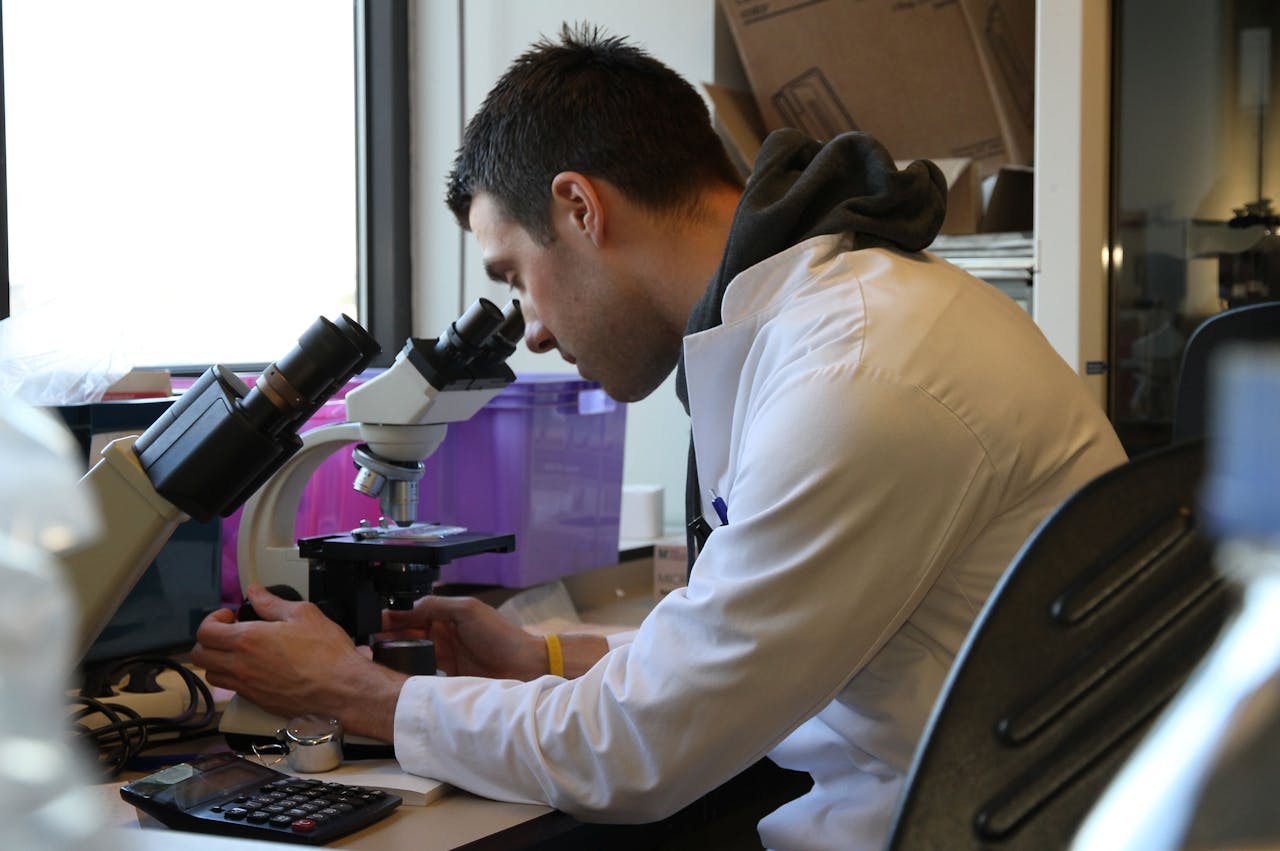 Onderzoeker Rik de Groen bekijkt bloedcellen van patiënten met virale hepatitis onder de microscoop.