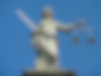 Een beeld van Vrouwe Justitia met een zwaard en een weegschaal.
