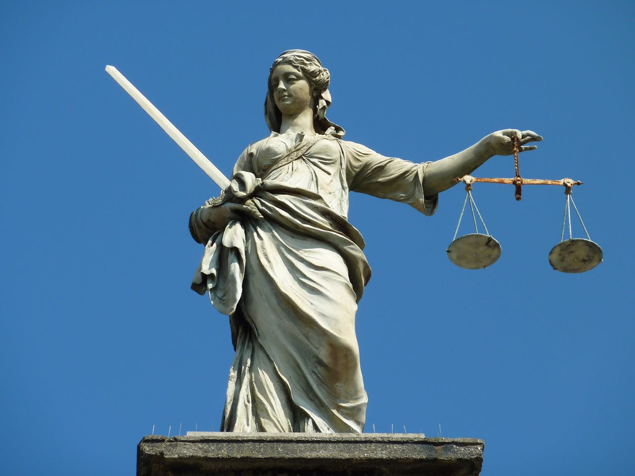 Een beeld van Vrouwe Justitia met een zwaard en een weegschaal.