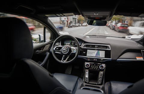 In de Verenigde Staten mag een zelfijdende auto zonder bestuurder de weg op, zoals deze taxi in San Francisco. Blik vanaf de achterbank op het dashboard en stuur van een zelfrijdende taxi van Waymo.