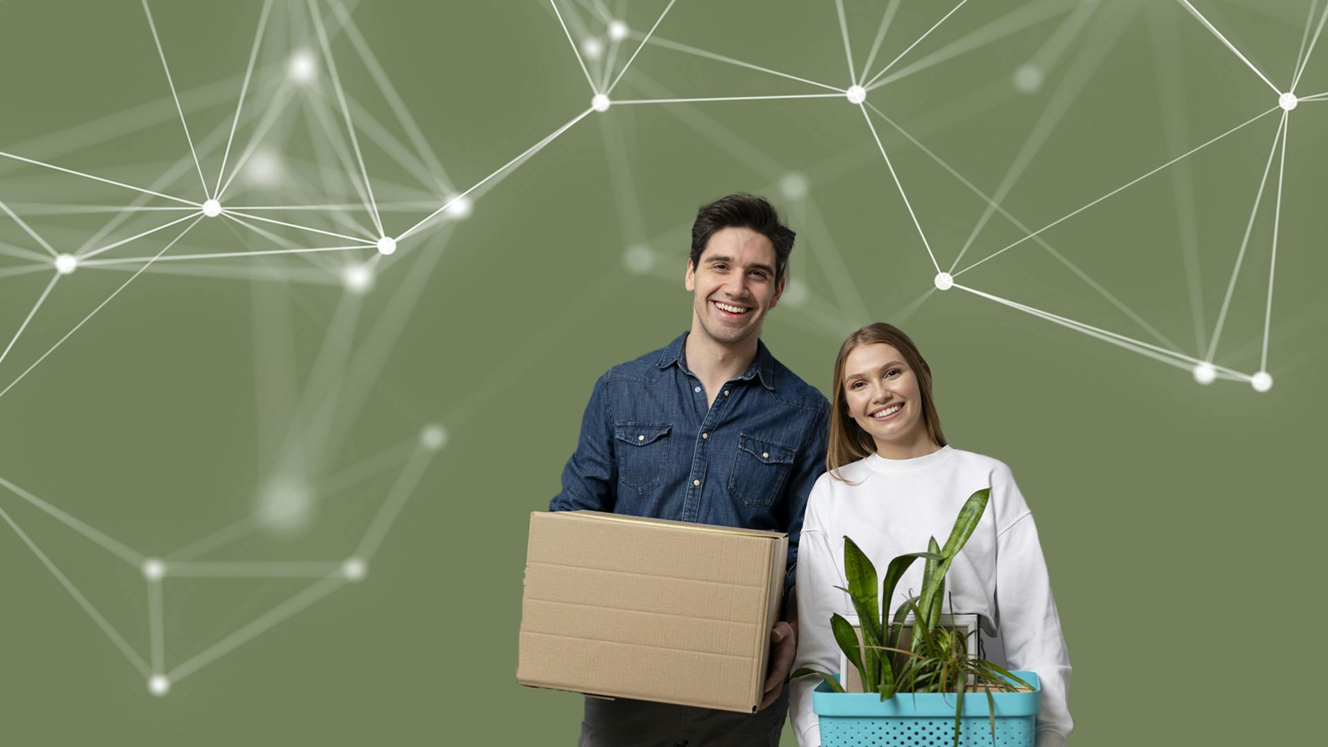 Een jongeman met donker haar en een jongedame met blond haar lachen naar de camera. De jongeman houdt een kartonnen doos vast, de jongedame een plant in een plantenbak.