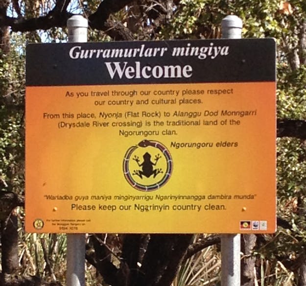 Welkomstbord in het leefgebied van de Ngarinyin. Geel welkomstbord van de Ngarinyin in West-Australië, met in twee talen (Engels en Ngarinyin) het verzoek om het land te respecteren en schoon te houden.