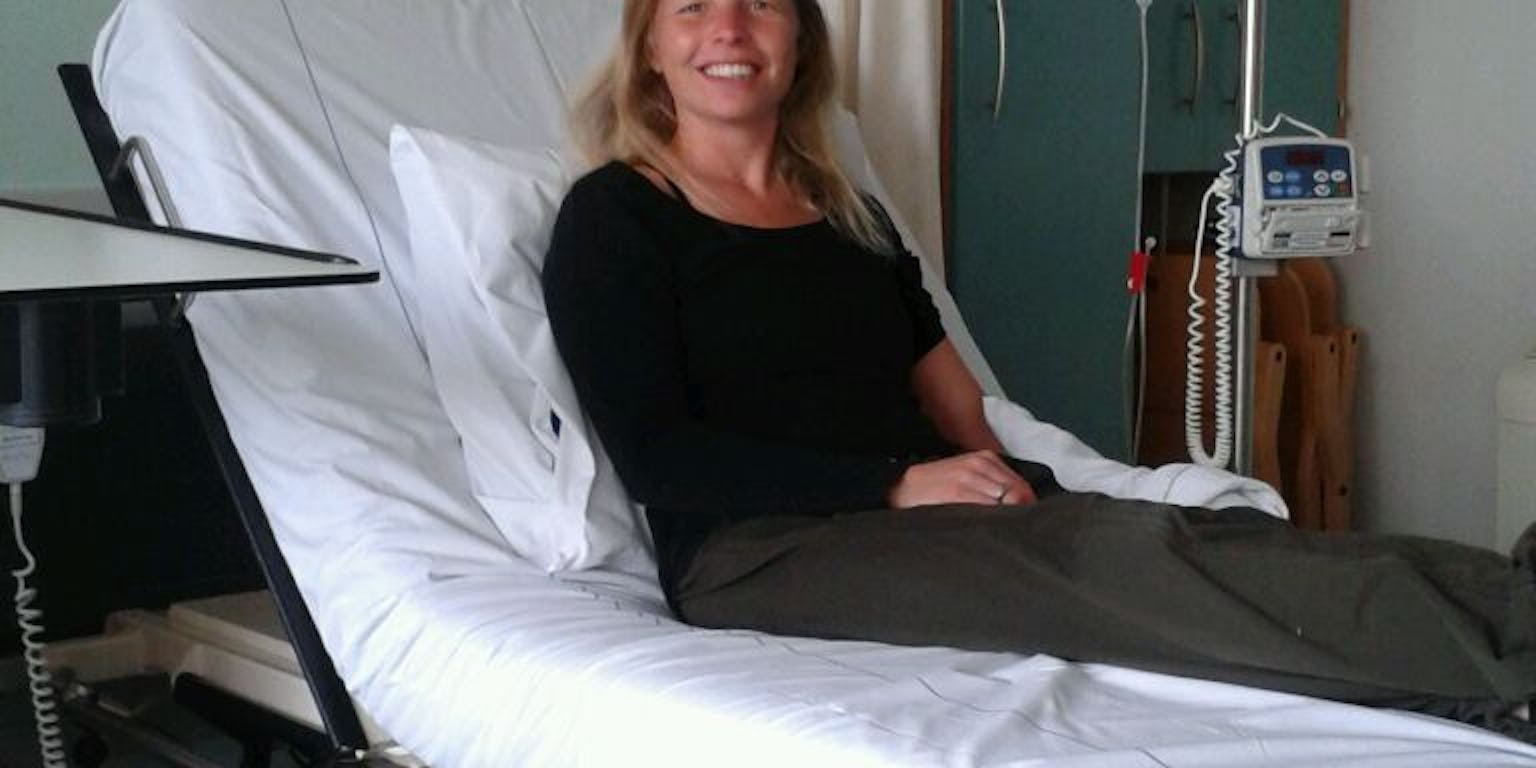 Een vrouw die op een ziekenhuisbed ligt.