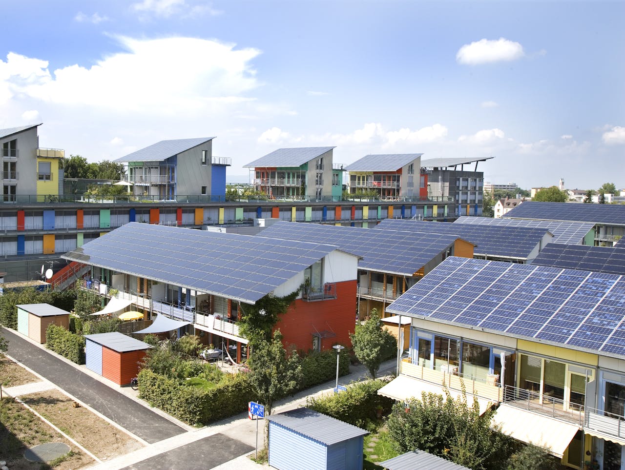 Een rij huizen met zonnepanelen op hun dak.