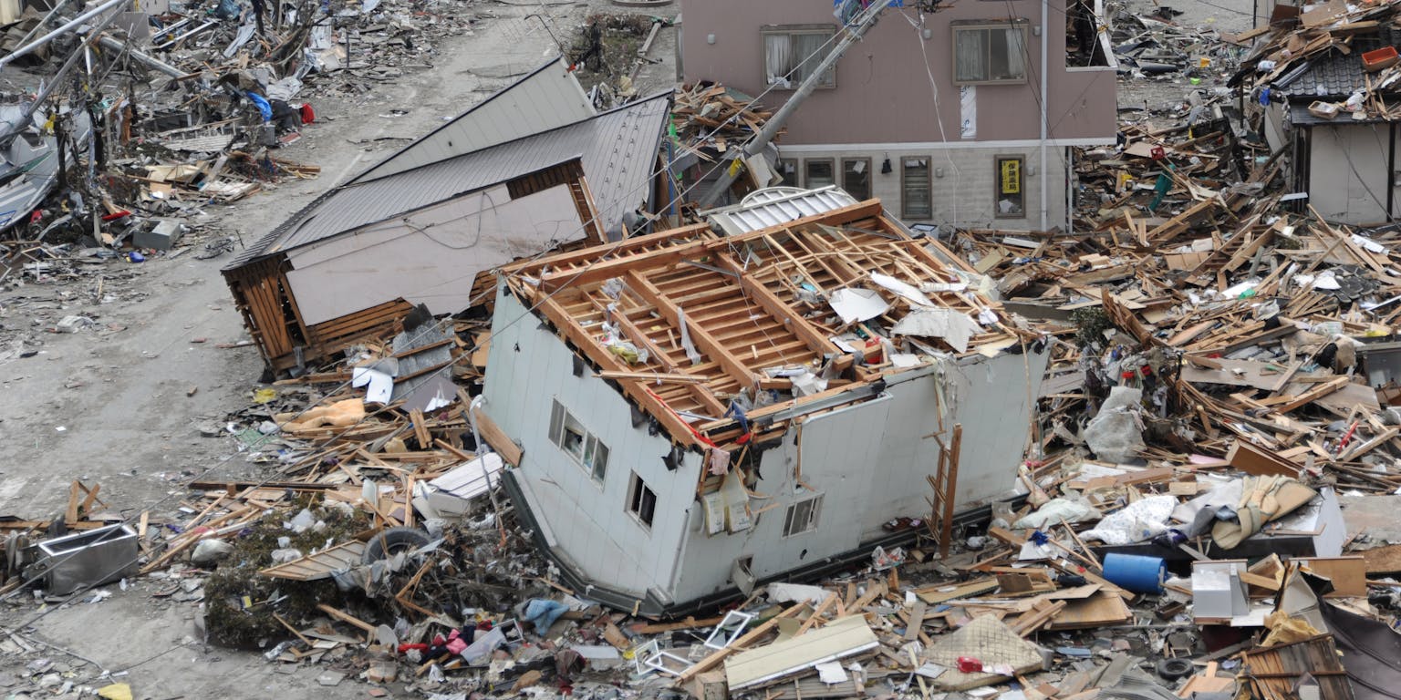Een luchtfoto van een verwoest huis in Japan door een aardbeving.