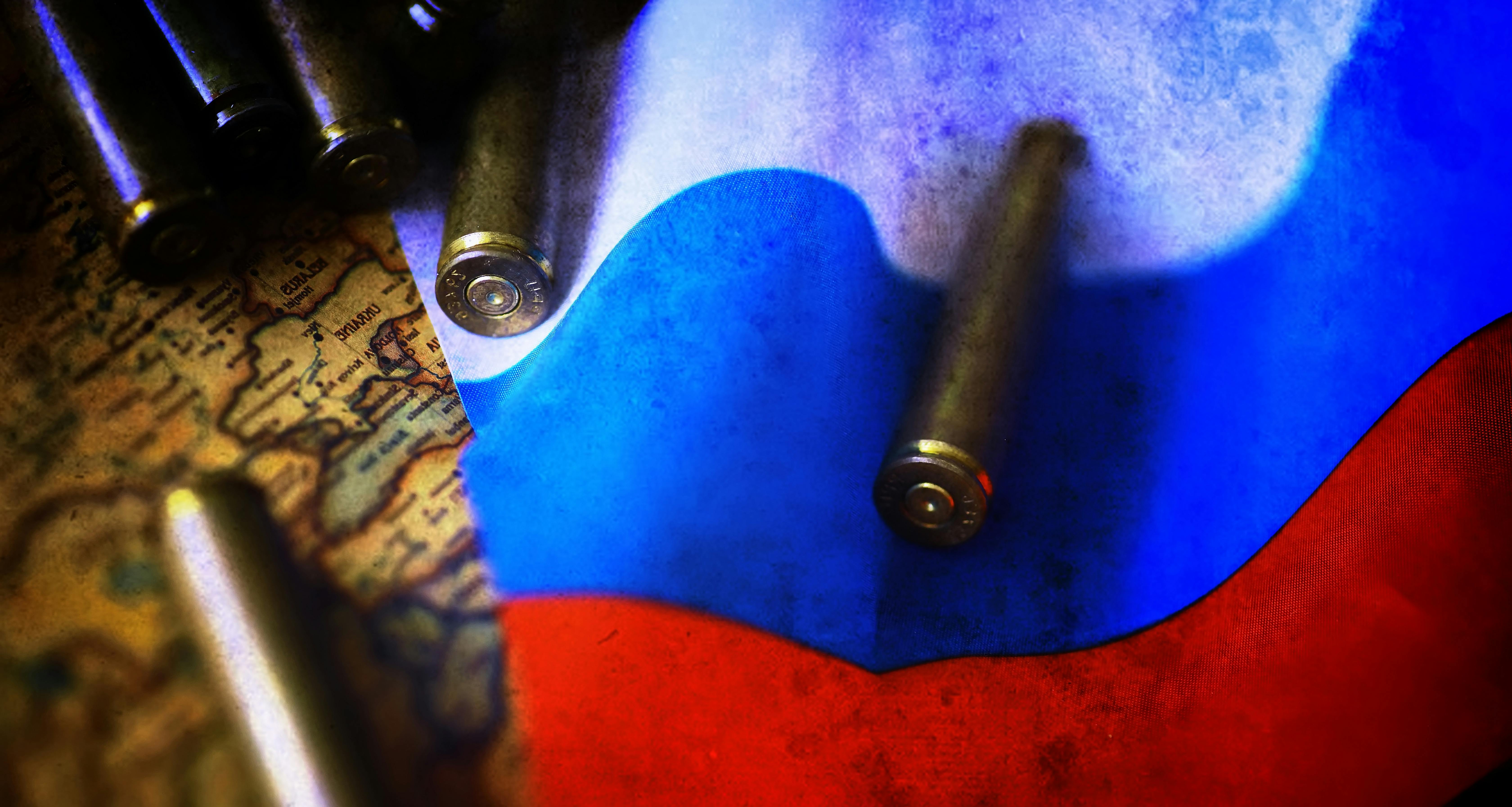 Een russische vlag ligt op een wereldkaart met daarop kogels