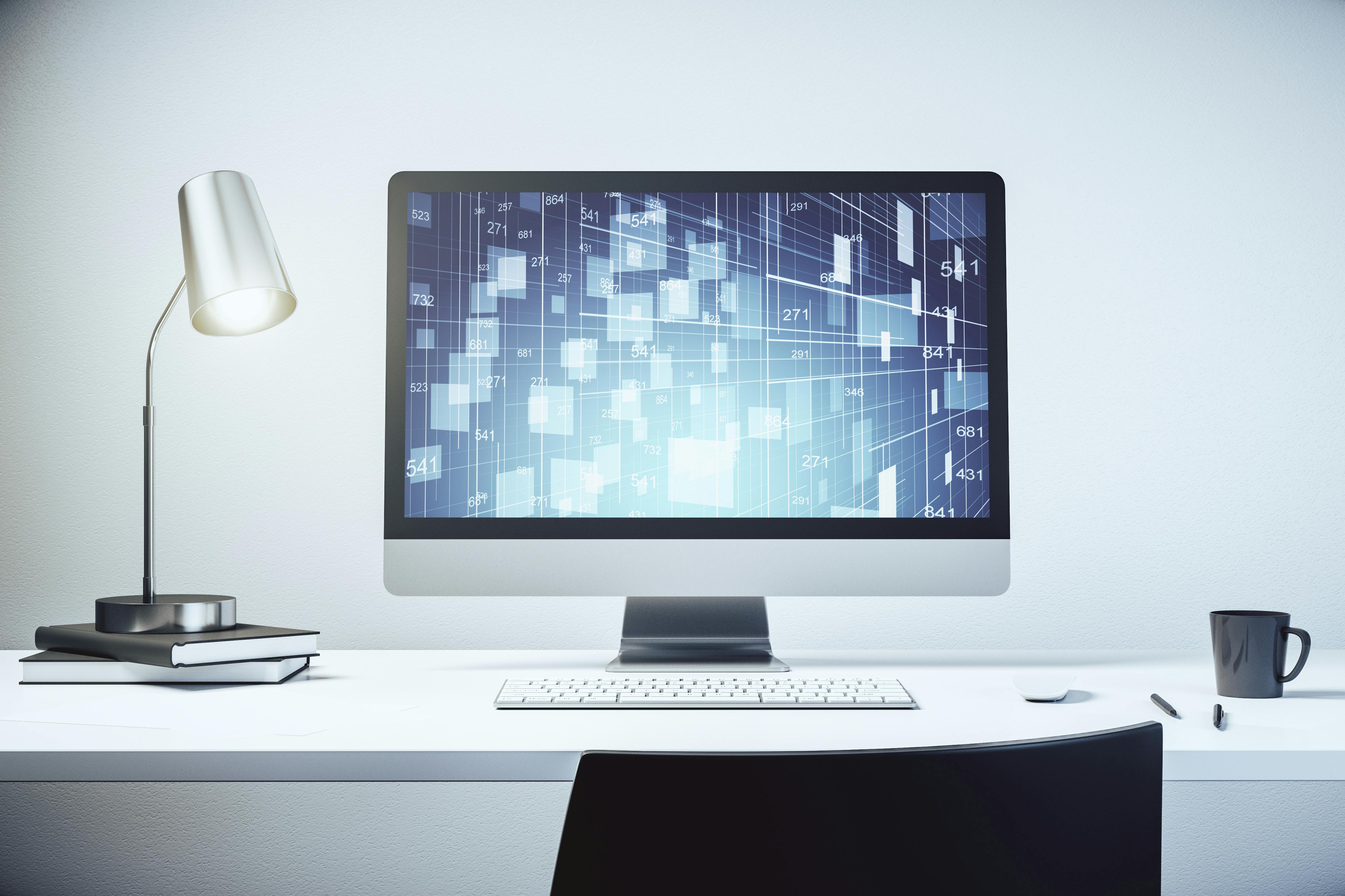 Stilleven van een computerscherm op een wit bureau met zilverkleurige bureaulamp, wit toetsenbord, zwarte mok en zwarte pennen. Op het scherm is een abstract grafisch patroon te zien.