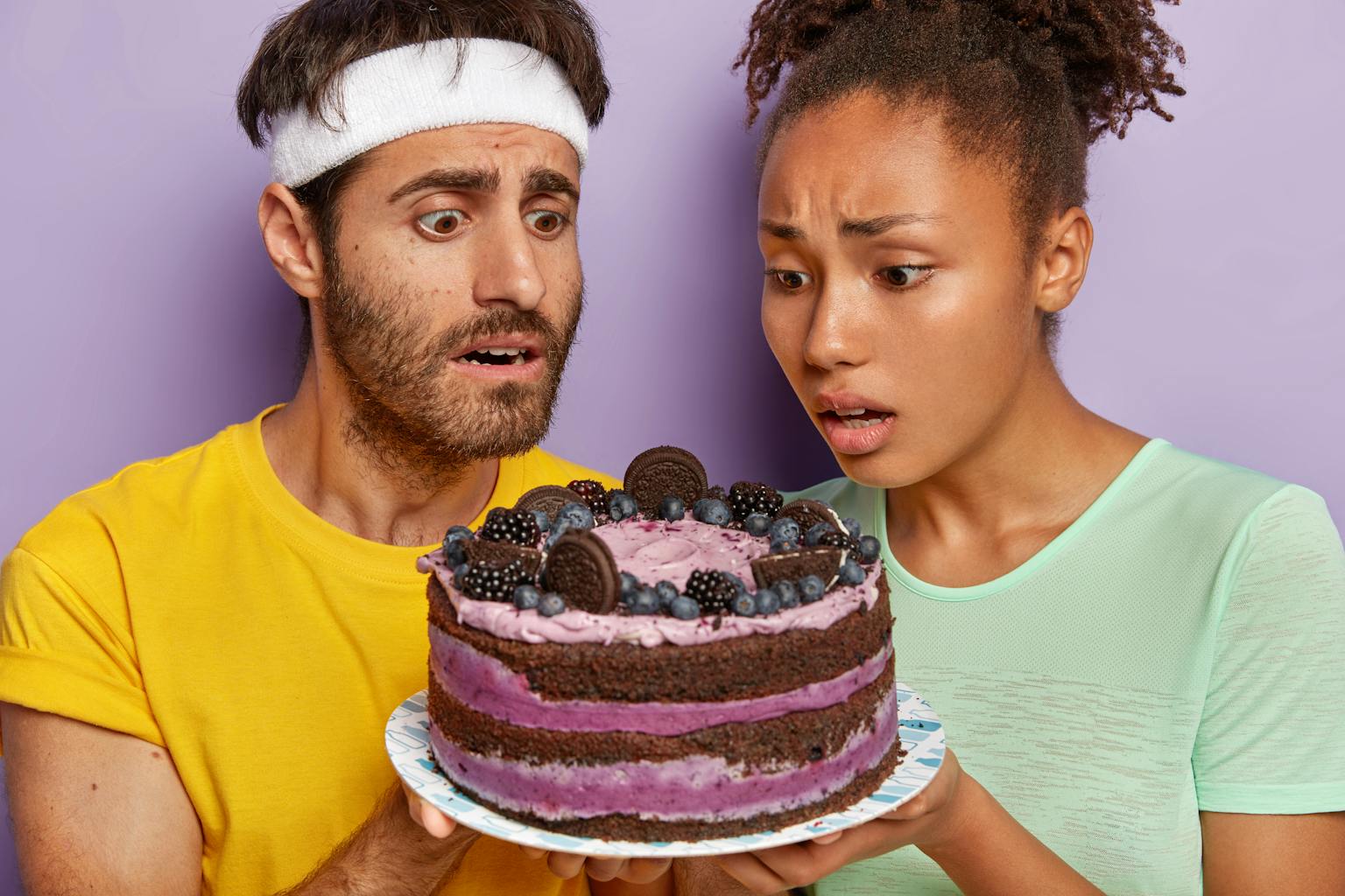 twee mensen kijken verlekkerd en wanhopig tegelijkertijd naar een taart