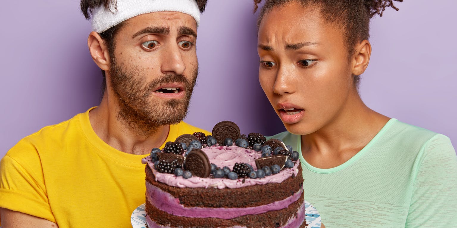 twee mensen kijken verlekkerd en wanhopig tegelijkertijd naar een taart