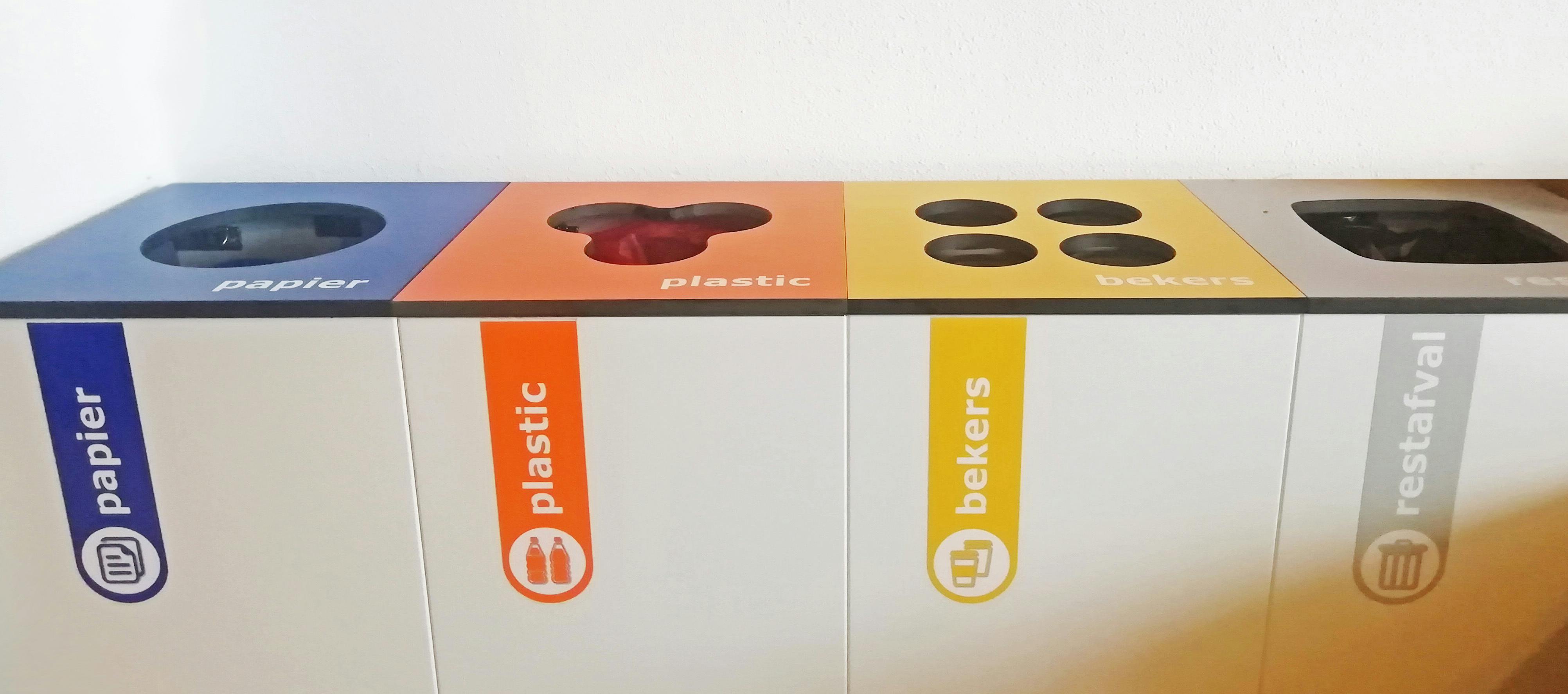 Een groep verschillend gekleurde recyclingbakken die naast elkaar zitten.