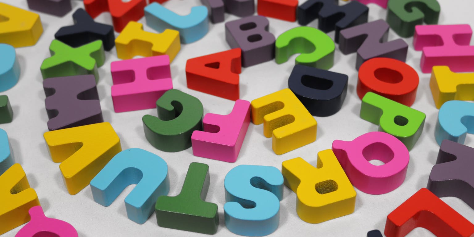 Een kleurrijke set houten alfabetletters gerangschikt in een cirkel.