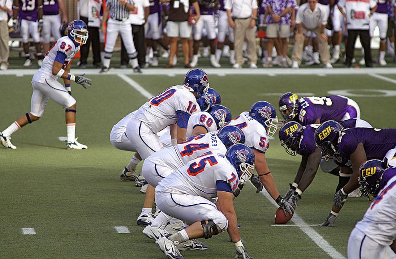 Twee teams staan aan de start van een American Football wedstrijd.