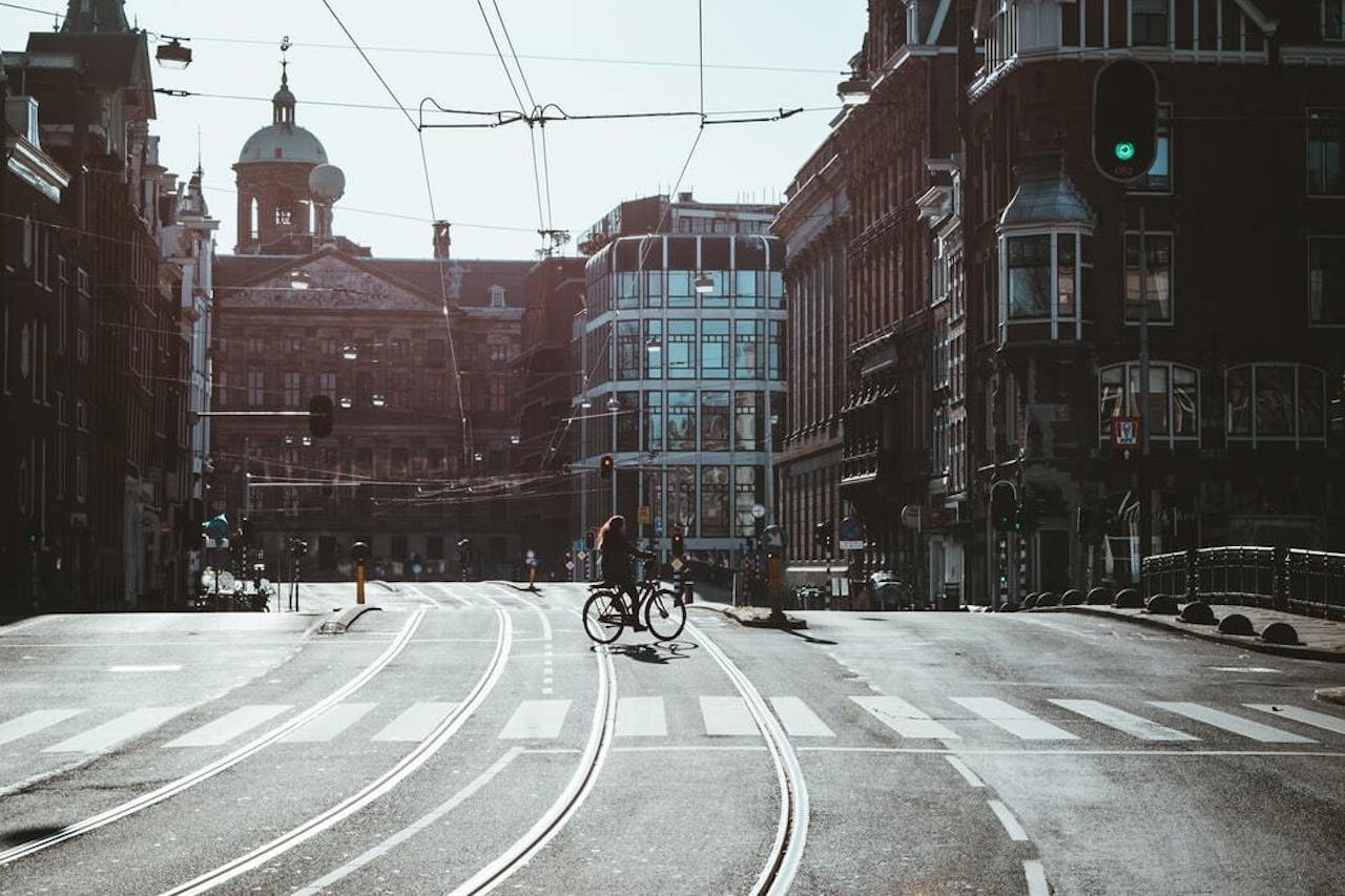 Een persoon die op een fiets rijdt in een straat in Amsterdam.