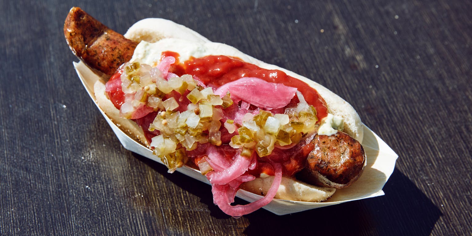 Een hotdog in een papieren bakje.