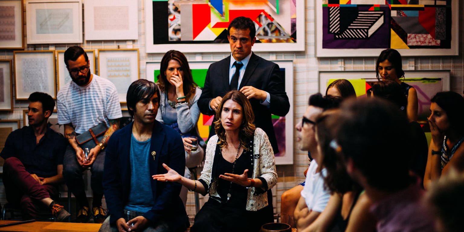 Een groep mensen zit in een kamer en voert een discussie met elkaar.