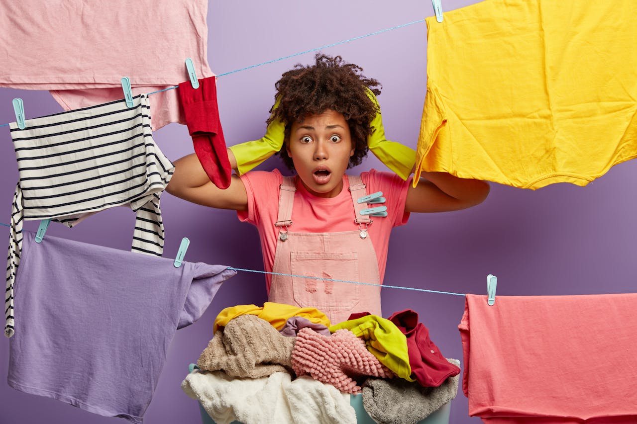 Wie betaalt de prijs van deze duurzame en noodzakelijke transitie in de kledingindustrie? jonge vrouw wordt gek van alle kleding
