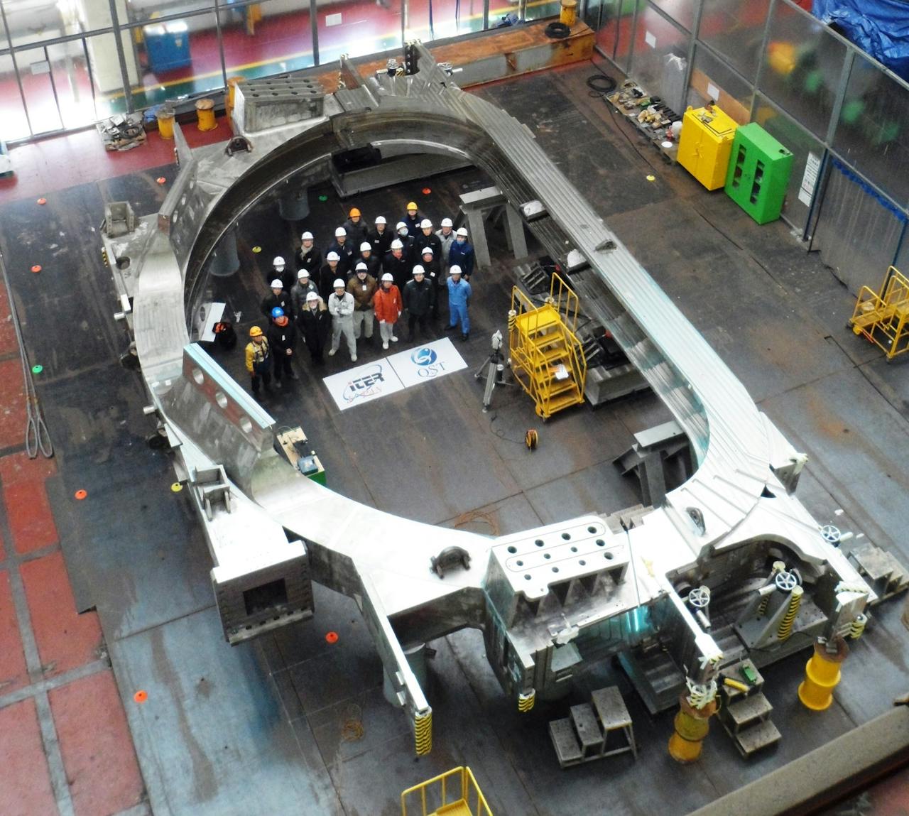 Een groep van ruim twintig mensen die werken aan een metalen onderdeel van kernfusiereactor ITER in Zuid-Frankrijk.