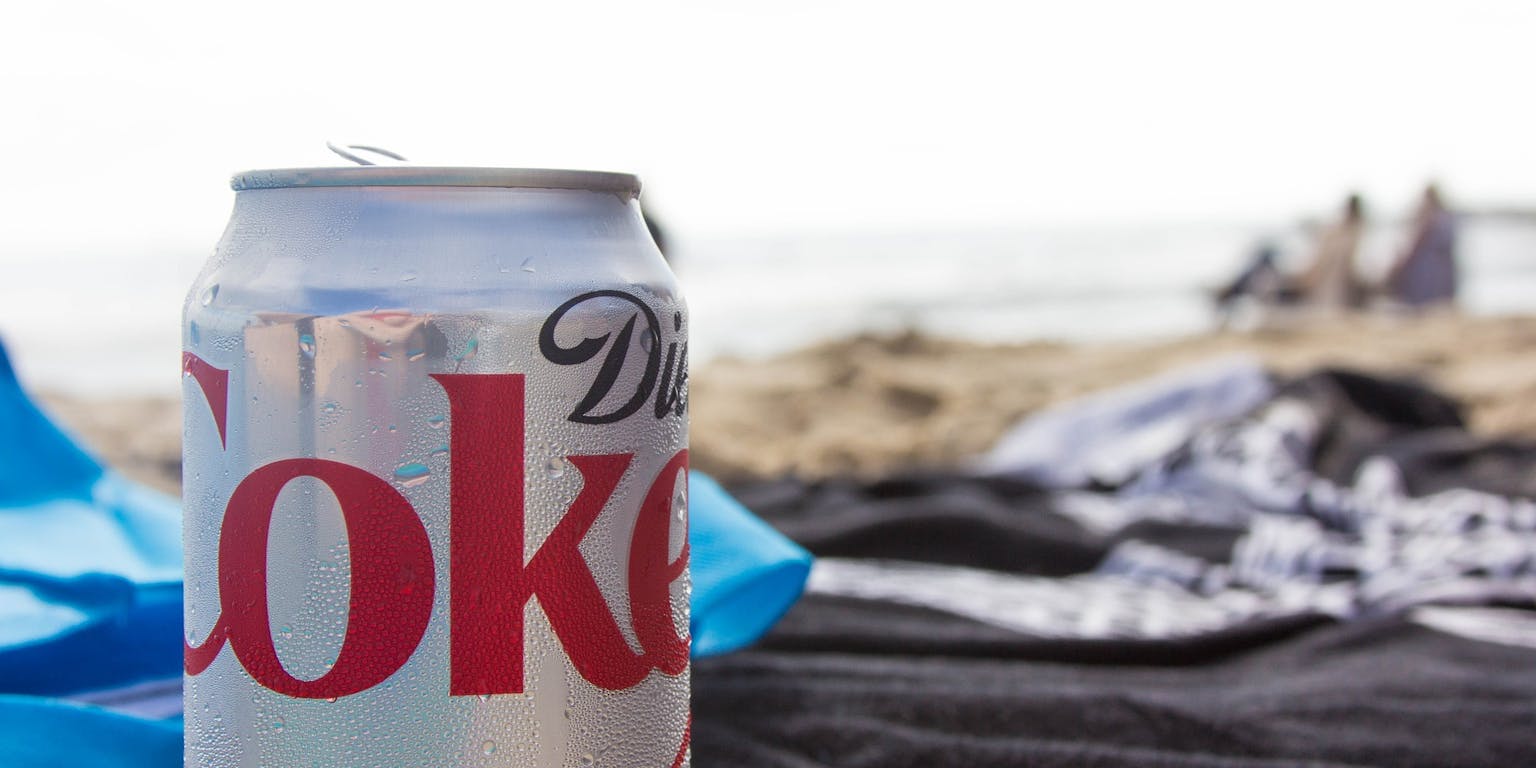 Blikje cola op het strand.