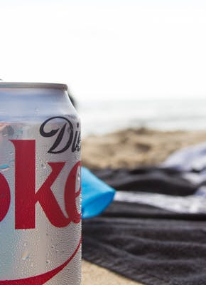 Blikje cola op het strand.