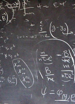 Een schoolbord met veel formules erop geschreven.