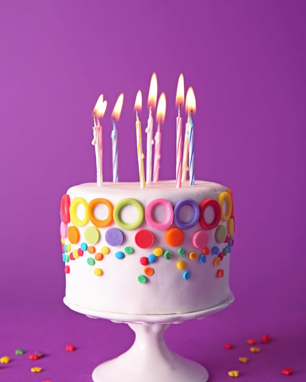 Ik kreeg een prachtige, gigantische en overdreven versierde taart, maar hoe ging ik 'm eerlijk verdelen? kleurig versierde taart met paarse achtergrond