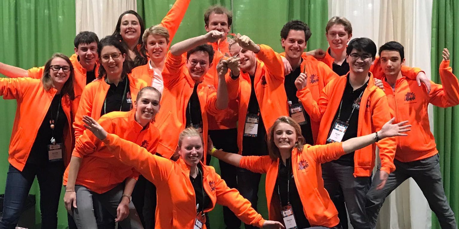 Een groepsfoto van het Leids studententeam. Alle personen op de foto dragen een oranje vest.