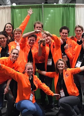 Een groepsfoto van het Leids studententeam. Alle personen op de foto dragen een oranje vest.
