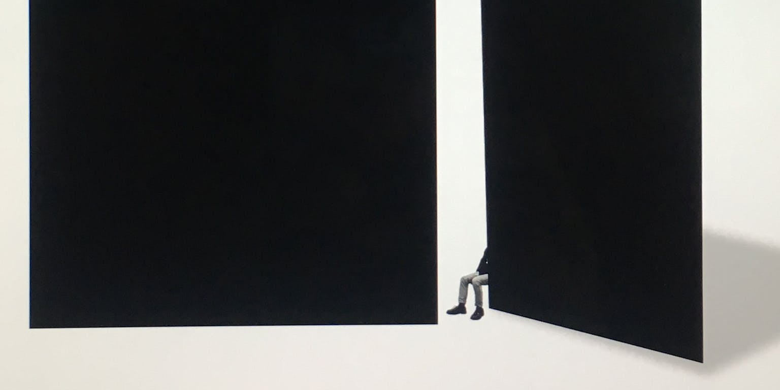 Een zwarte achtergrond met een witte uitsnede. In deze witte uitsnede zijn de benen van een persoon te zien.