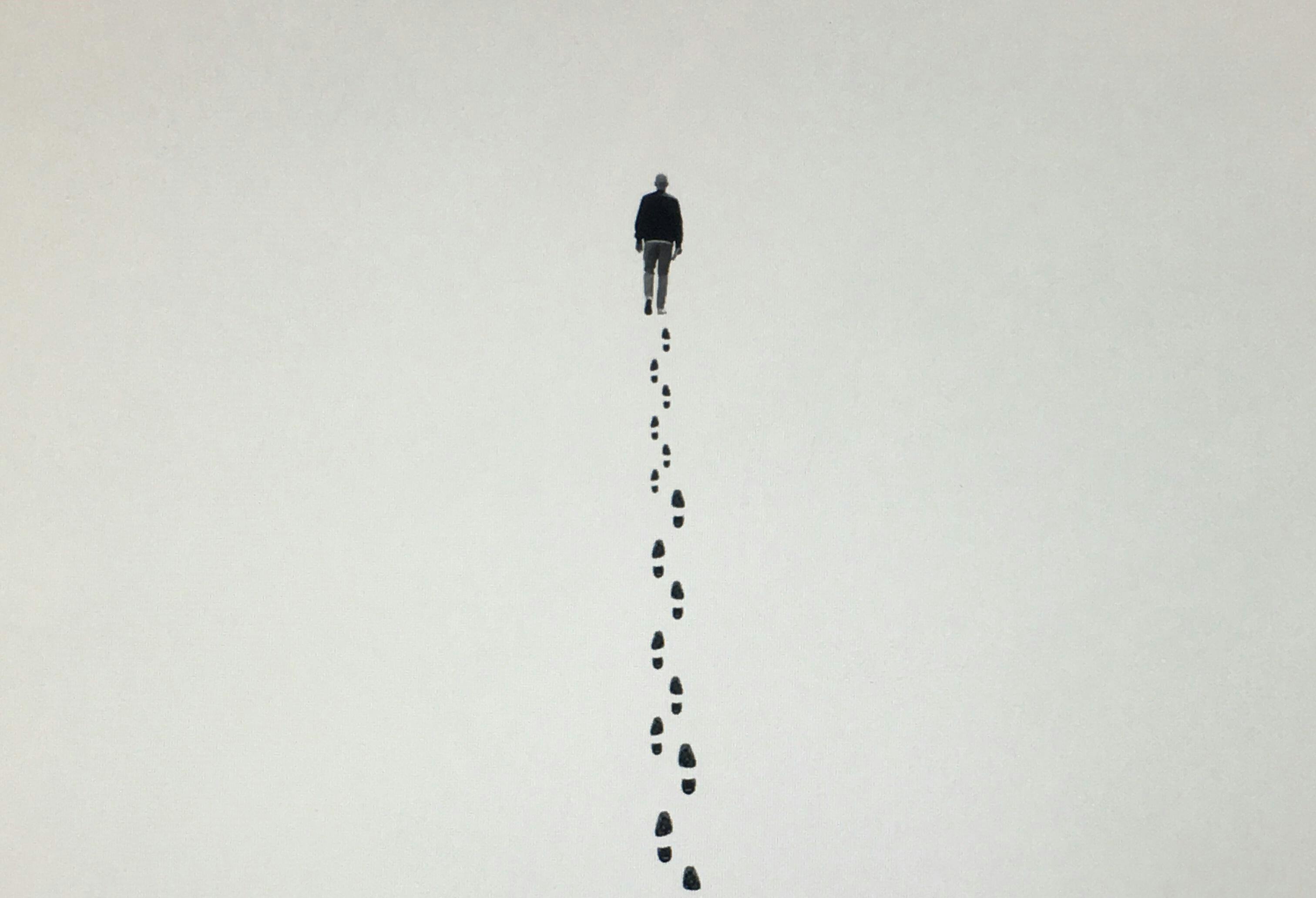 Een tekening van een persoon die aan het wandelen is. Er zijn voetsporen te zien.