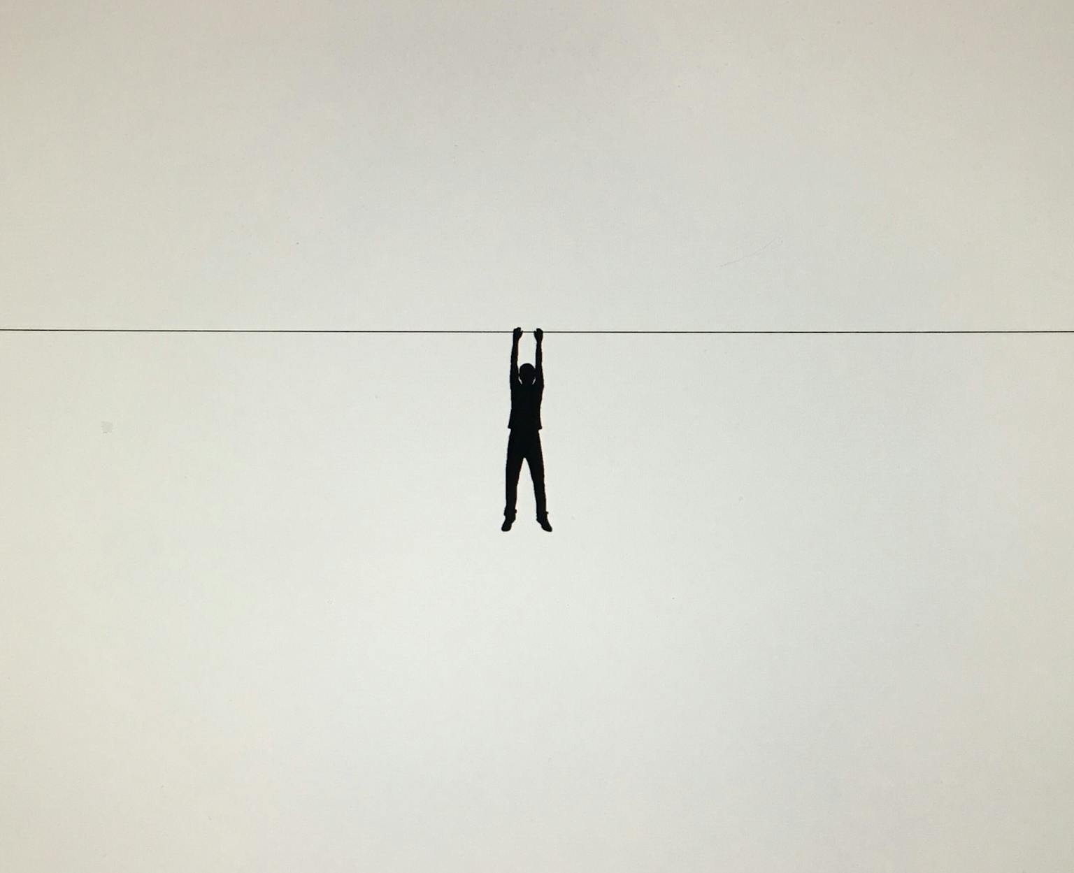 Een silhouet van een persoon die aan een draad hangt.