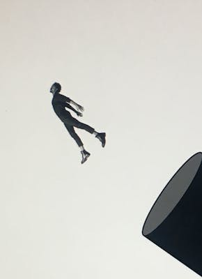 Een silhouet van een man die uit een ronde koker springt.