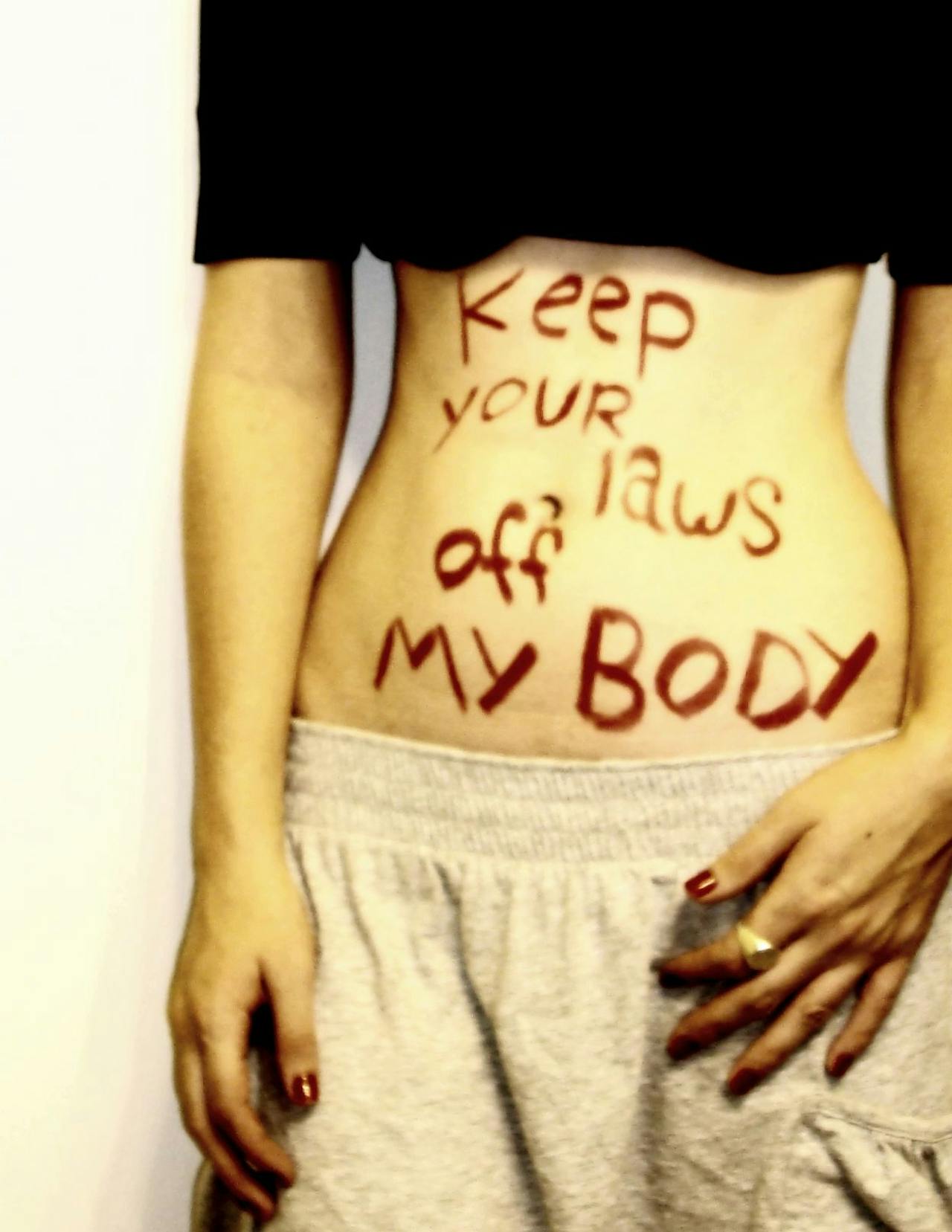 Protesttekst op de buik van een vrouw: ‘Houd de wetten weg van mijn lichaam’.