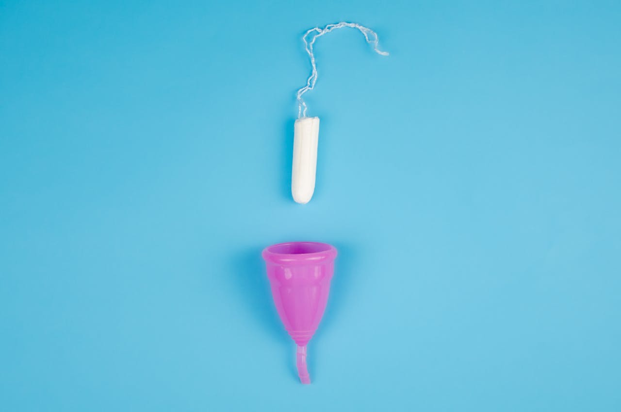 een tampon en menstruatiecup op een blauwe achtergrond