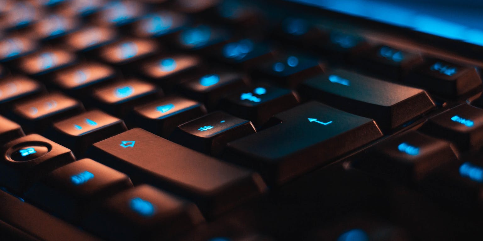 Een close-up van een computertoetsenbord met blauwe lichten.