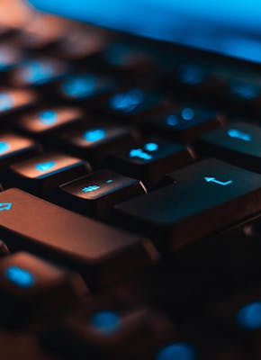 Een close-up van een computertoetsenbord met blauwe lichten.