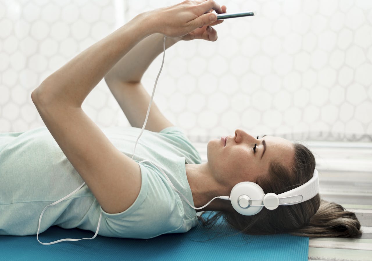 Je kunt je lichamelijk en mentaal beter voelen door naar muziek te luisteren. Jonge vrouw luistert ontspannen naar muziek via een koptelefoon
