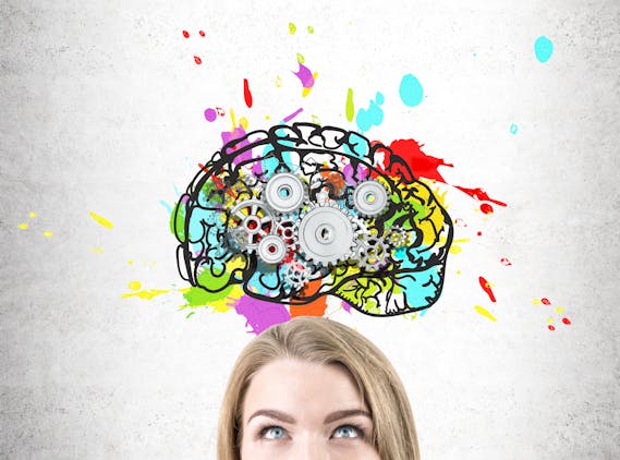 bovenste helft van gezicht (ogen en haar) van een tiener die naar een getekende, gekleurde hersenen kijkt