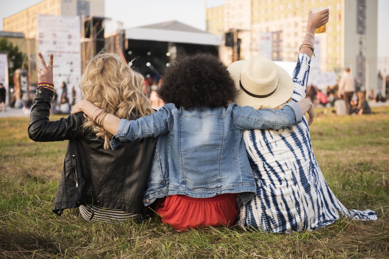 drie jonge vrouwen knuffelen samen tijdens een concert