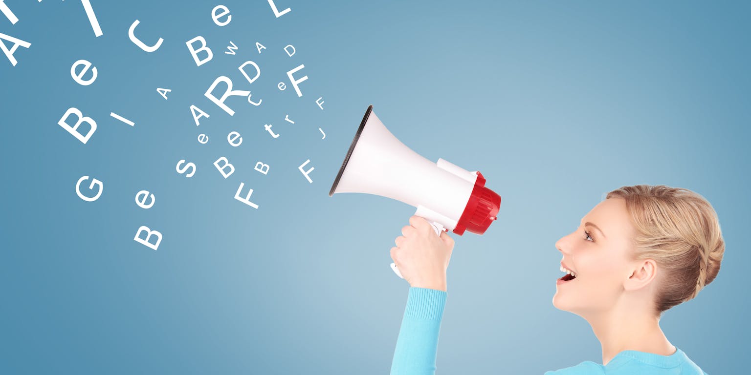 vrouw met megafoon kijkt naar alfabetletters