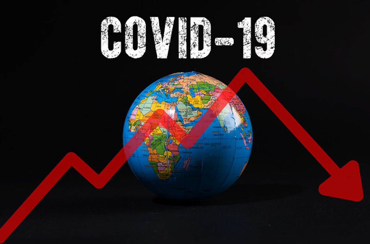 Een wereldbol met het woord covid-19 erop. Er is ook een dalende rode pijl te zien.