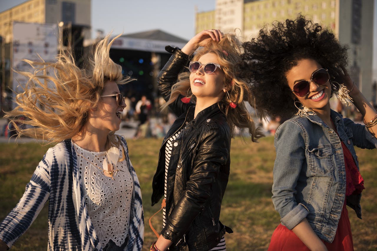 drie jonge vrouwen dansen samen tijdens een muziekconcert