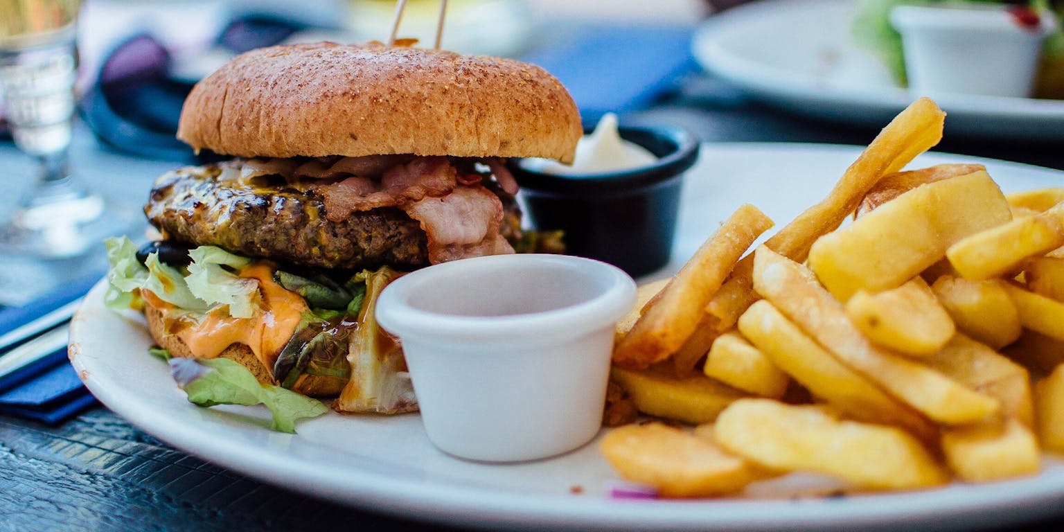 Een hamburger en friet op een bord in een restaurant.