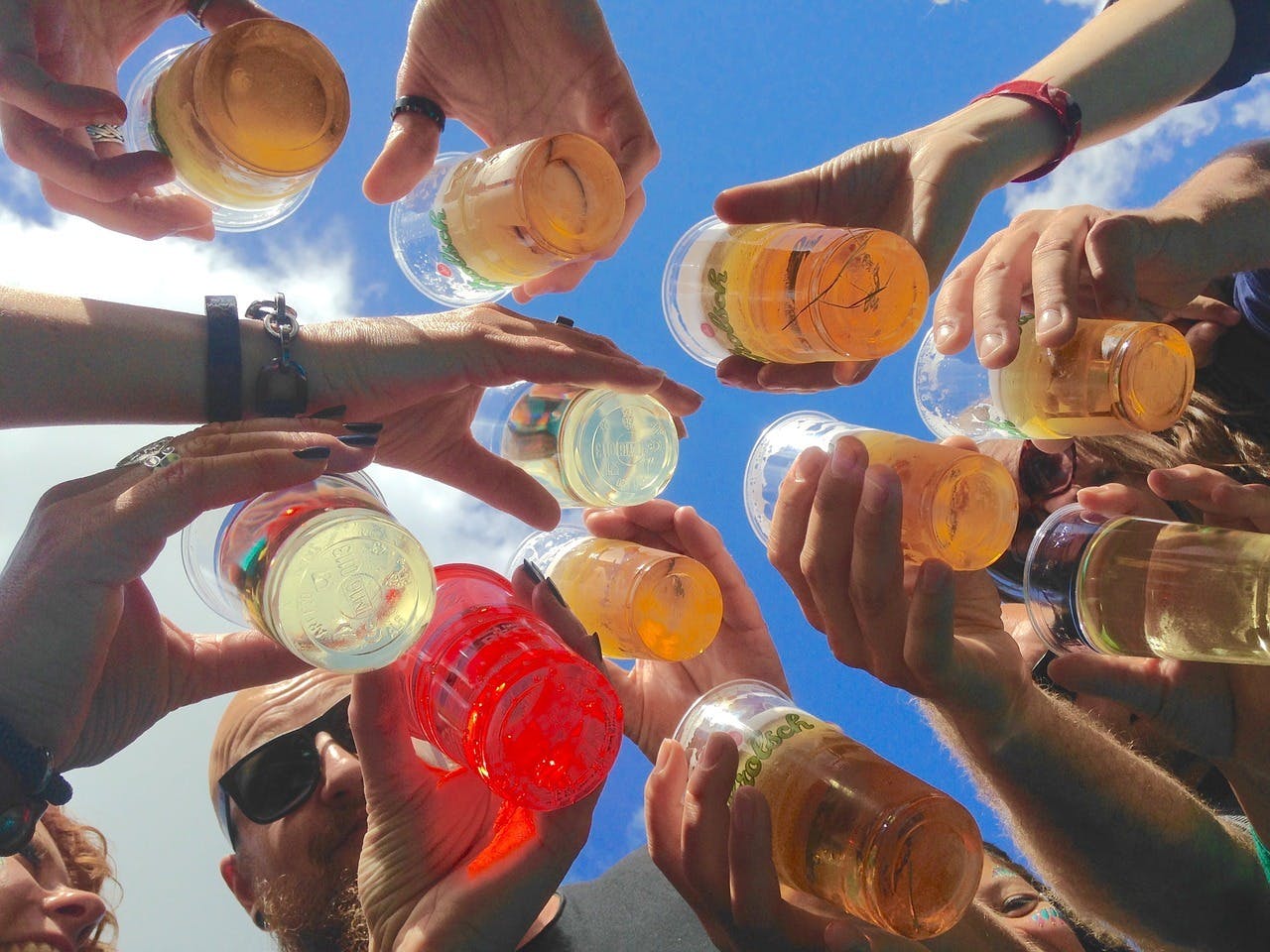 Een groep mensen die bierglazen in de lucht houden.