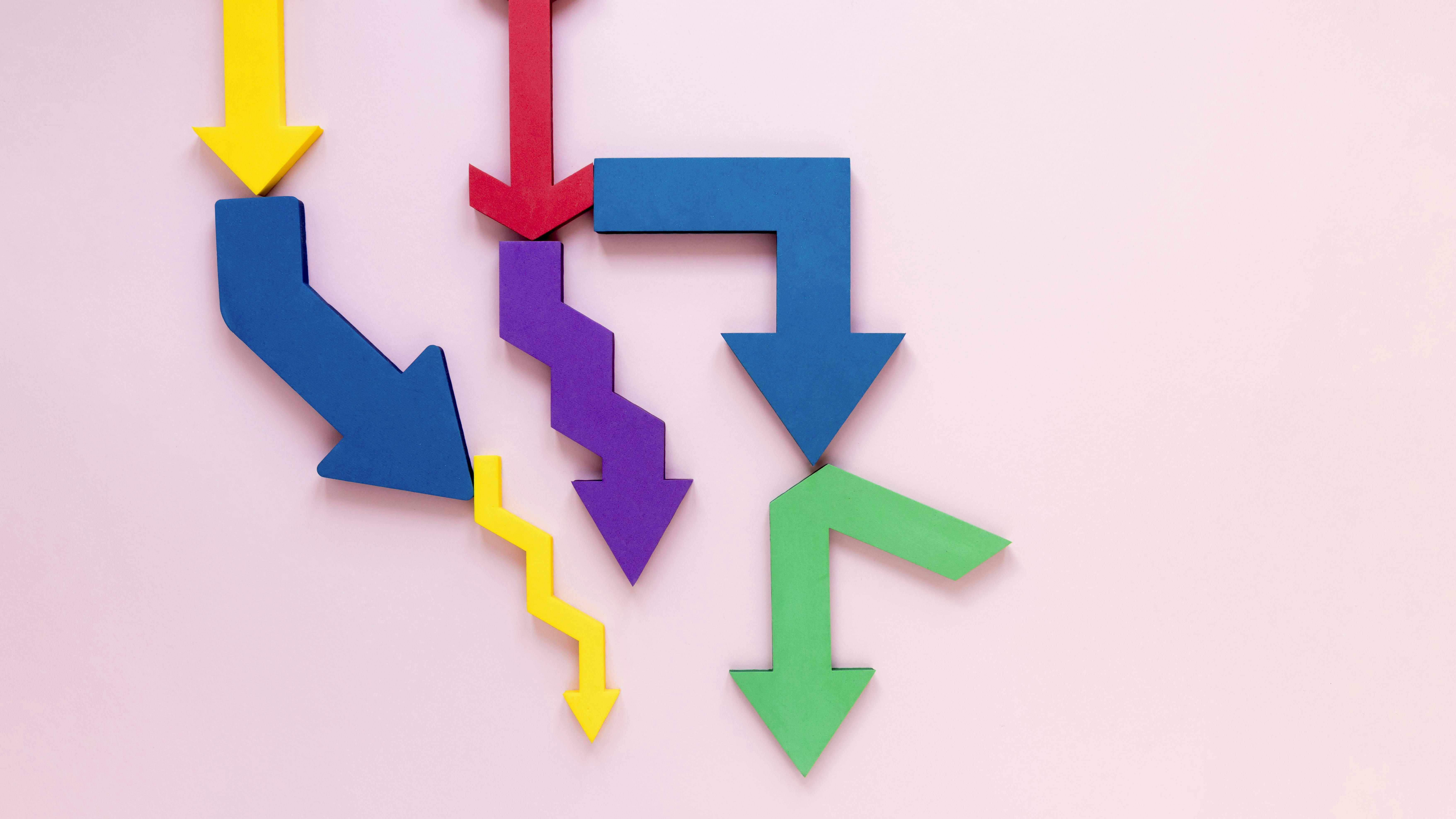 Pijlen in verschillende kleuren die alle kanten op gaan, tegen een roze achtergrond