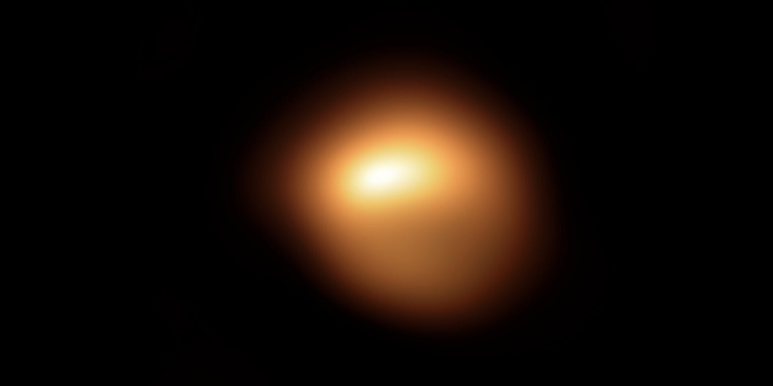 Een oranje vlek in het donker die de ster Betelgeuse voorstelt.