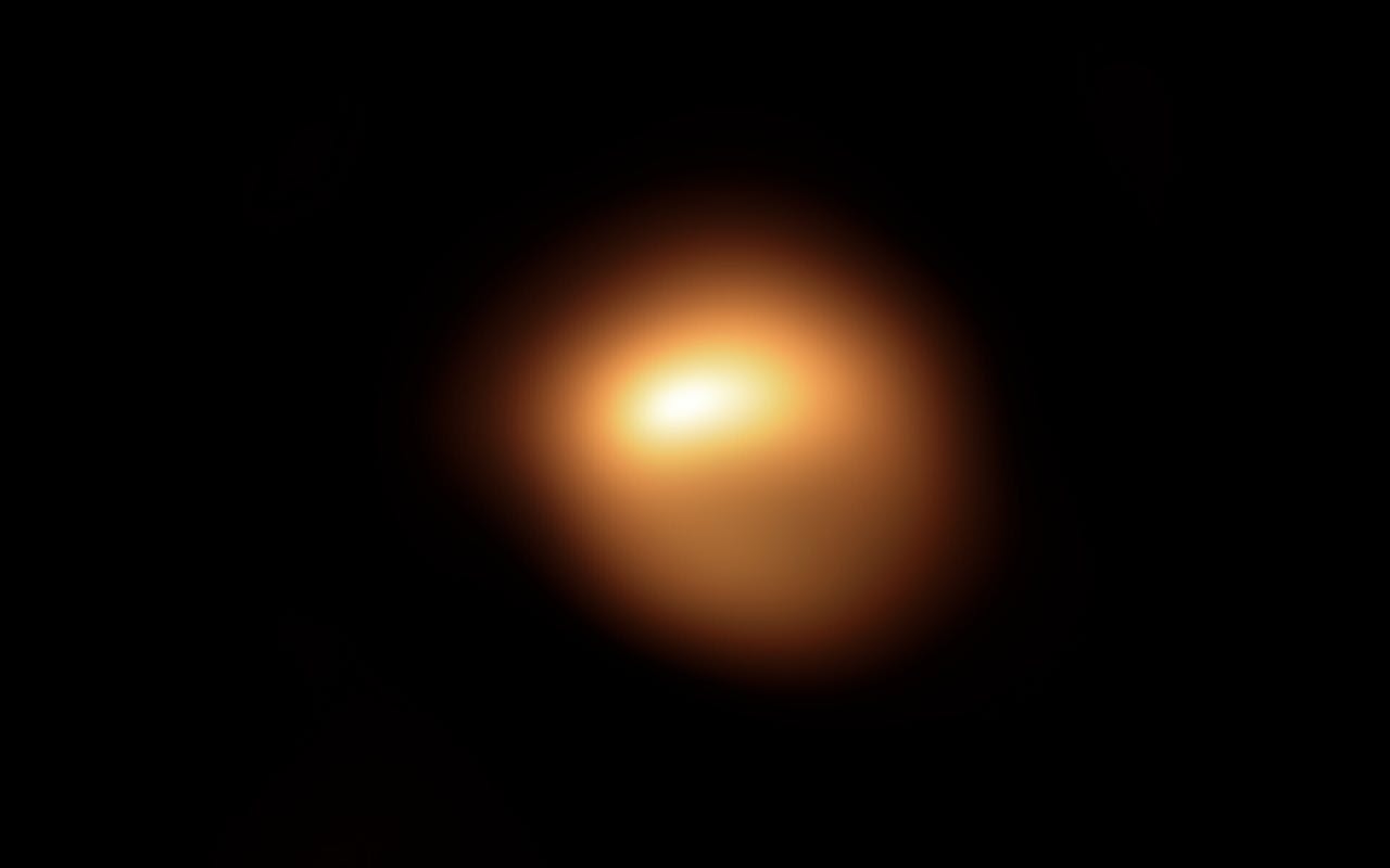 Een oranje vlek in het donker die de ster Betelgeuse voorstelt.