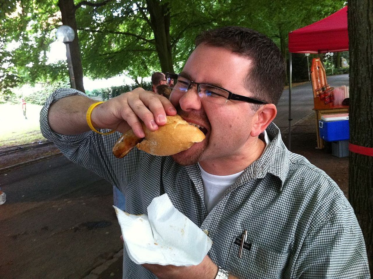 Een man die een hotdog eet.